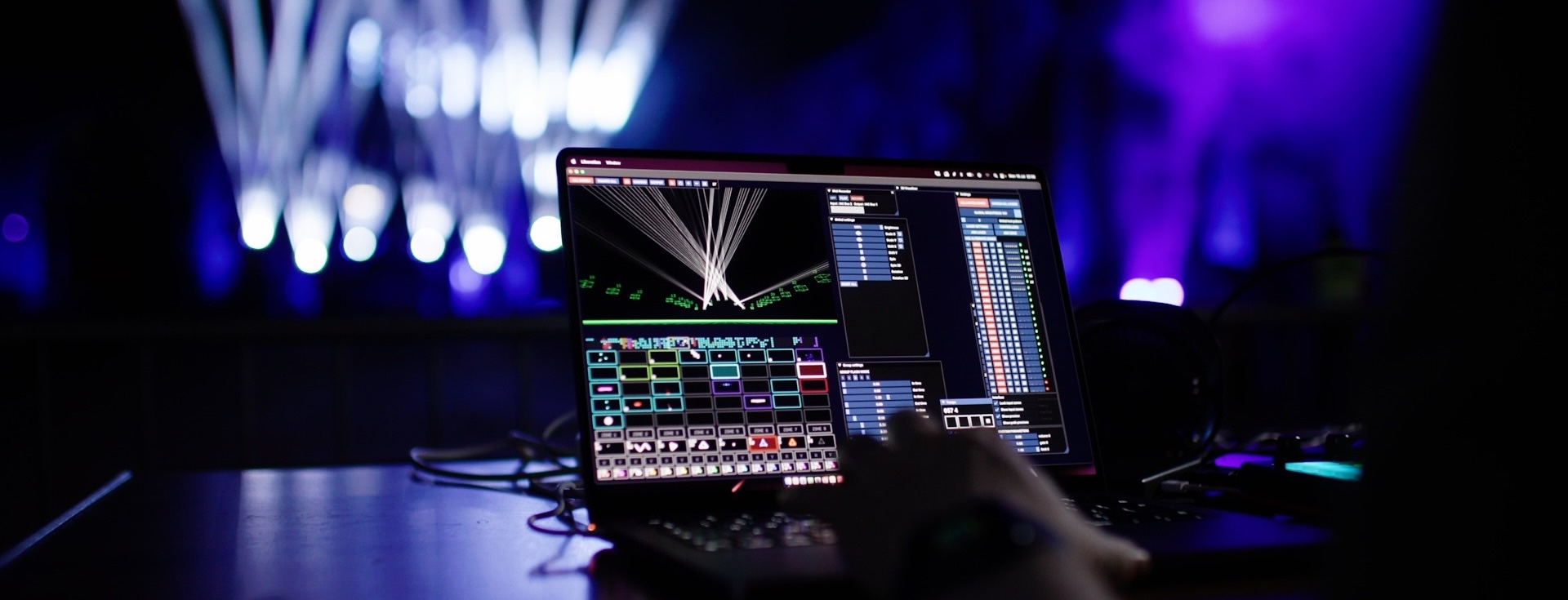 A laptop running Liberation with lasers in the background