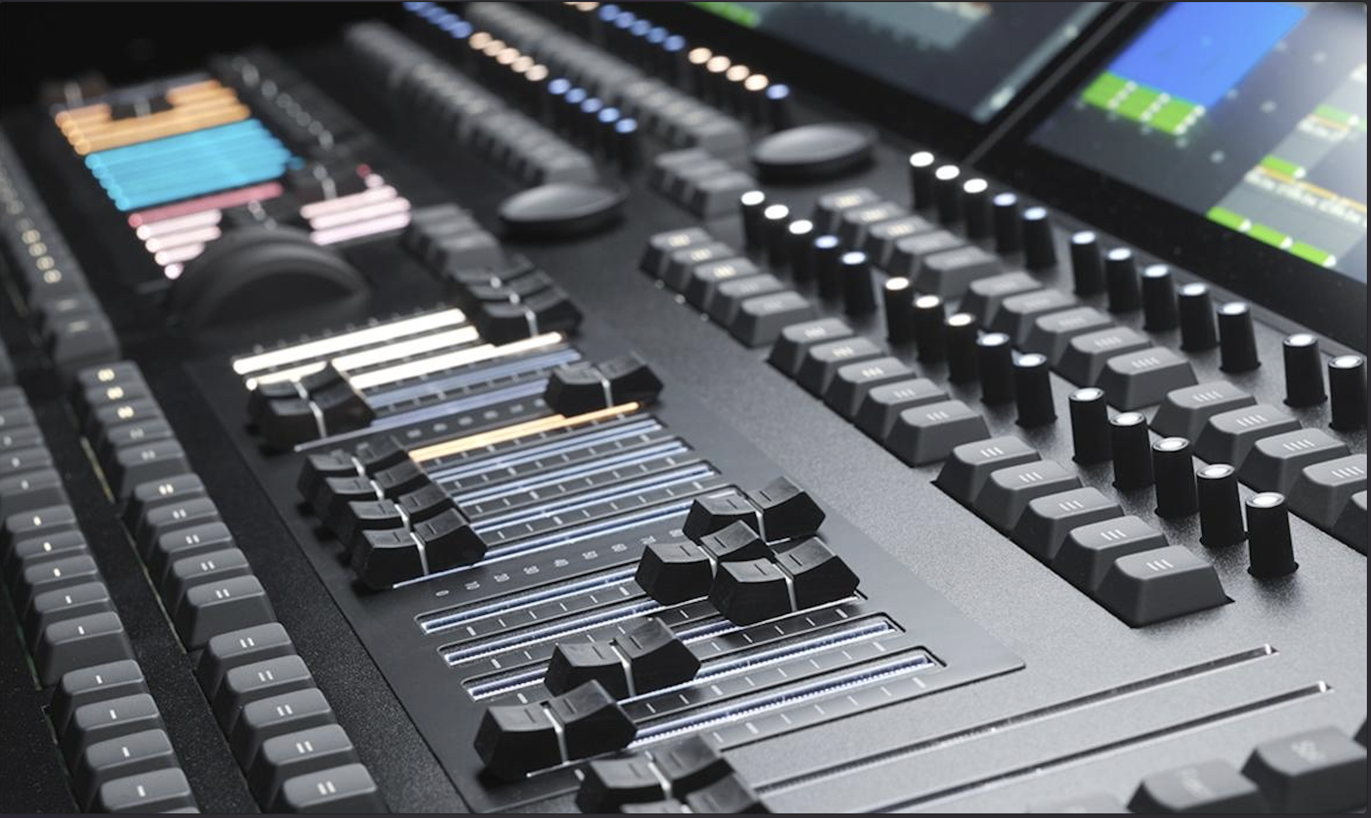 Close-up of a grandMA lighting console with faders, encoders and touchscreens